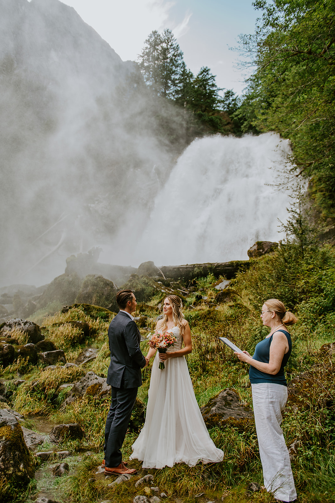 West coast wedding ceremony in front of a waterfall