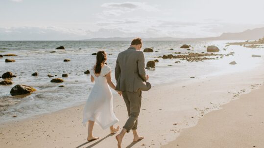 Beach elopement couple walking on the beach