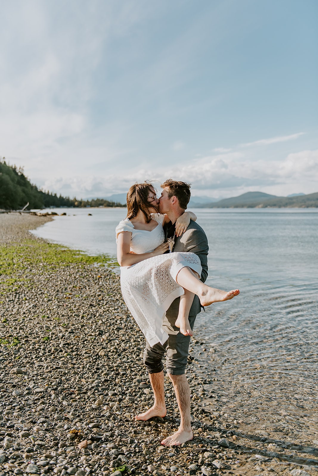 bride and groom kissing at beach wedding
