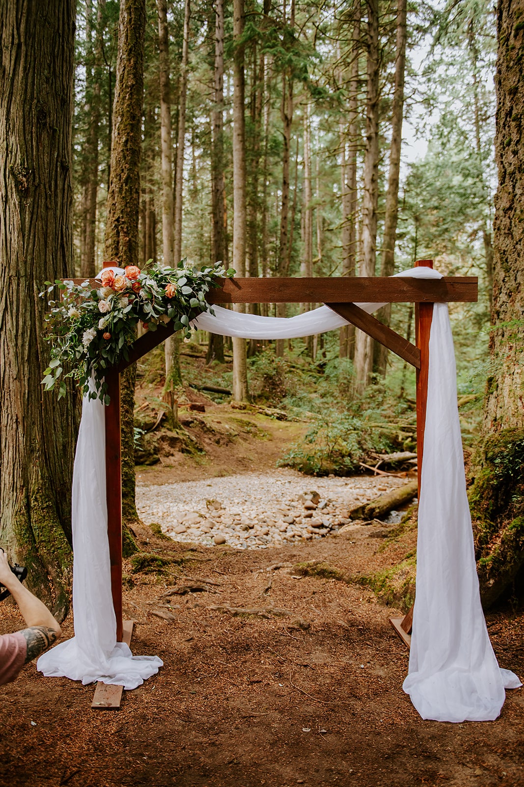 Wood wedding arch with flowers and drape